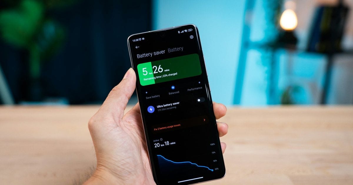Una mano tiene uno smartphone Android con la schermata della batteria: autonomia residua e grafico dei consumi