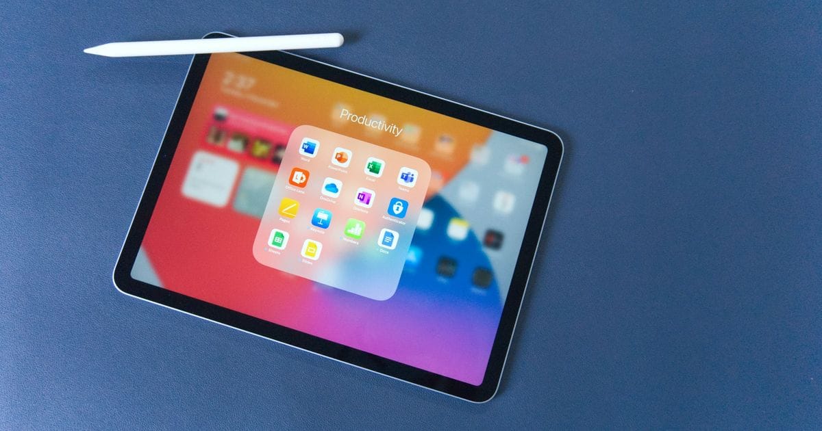 iPad con una cartella di app aperta sullo schermo e una Apple Pencil su un piano blu